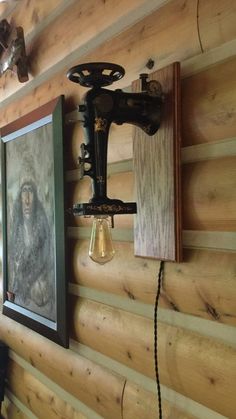 an old fashioned light fixture is mounted on the wall next to a framed painting and lamp