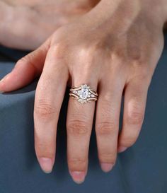 a woman's hand with a diamond ring on her left and the other hand holding an engagement ring