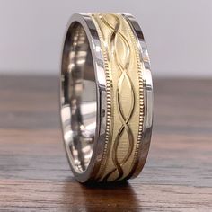 two tone gold wedding band with intricate engraving on the inside, and inlays to the outside