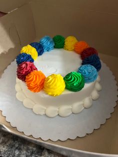 a white cake with rainbow frosting in a box