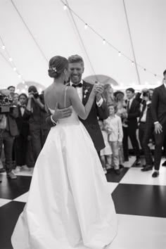 a bride and groom dance on the dance floor at their wedding reception in black and white