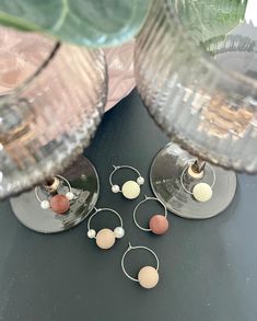 three wine glasses sitting on top of a table next to each other with small balls in them