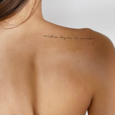 the back of a woman's shoulder with writing on it