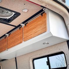 the inside of a vehicle with wood paneling on the floor and window sill