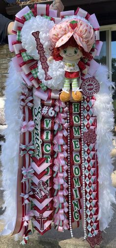 a large red and white christmas decoration hanging from the side of a building with decorations on it