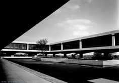 black and white photograph of the outside of an office building with walkways leading up to it