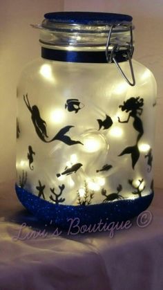 a glass jar filled with lights and sea animals on the inside is sitting on a table