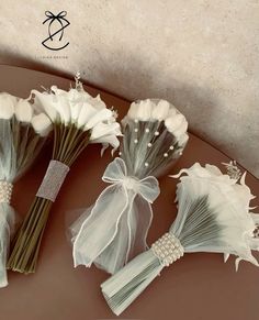 wedding bouquets with ribbons and flowers on a table