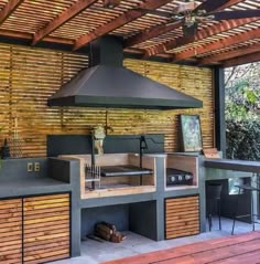 an outdoor kitchen that is built into the side of a building with wood flooring