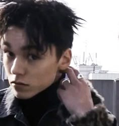 a man with black hair talking on a cell phone