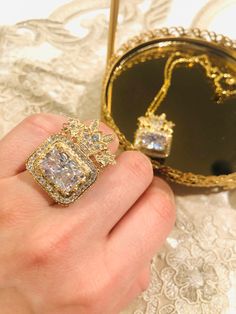 Koohe-nour Dimond of Nader Shah.Golden ring and necklace ,gold plated,Non Allergy and sensitivity    Length 2inch Width. 2inch Anti allergy Adjustable size for golden ring دریای نور درشت ترین و زیباترین الماس برلیان در میان گوهرهای سلطنتی ایران و یکی از گوهرهای معروف جهان است. این الماس در جنگ با هند در سال ۱۷۳۹ میلادی همراه با نادر شاه افشار بودهاست. دریای نور پس از قتل نادر به نوهٔ او شاهرخمیرزا (آخرین پادشاه افشار) رسید و سپس به دست امیر علم خان خزیمه و بعد به محمد حسن خان قاجار و بعد به لطفعلیخان زند و سر انجام به دست آقا محمدخان قاجار افتاد Yellow Gold Plated Diamond Jewelry, 14k Gold Plated Jewelry For Weddings, 14k Gold Plated Wedding Jewelry, Exquisite Hand Set Gold Rings, Luxury Gold Crown Jewelry, Regal Diamond Jewelry For Formal Occasions, Regal Diamond Wedding Jewelry, Exquisite Gold Jewelry As Gift, Exquisite Gold Jewelry Gift