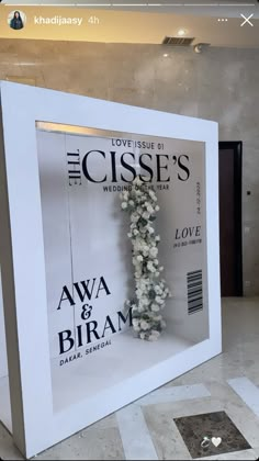 a white frame with flowers on it in front of a sign that says the cises