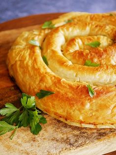 a pastry is sitting on top of a cutting board next to a sprig of parsley