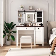 a bedroom with a bed, desk and mirror on it's wall next to a potted plant