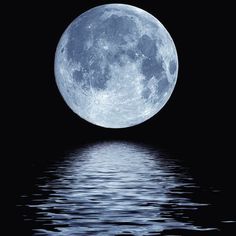 a full moon is reflected in the water