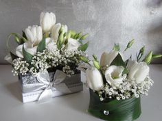 two vases filled with white flowers on top of a table