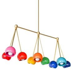 an assortment of colorful balls hanging from a brass chandelier with four different colors