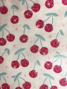 the fabric has cherries on it and stars in the background, as well as pink dots