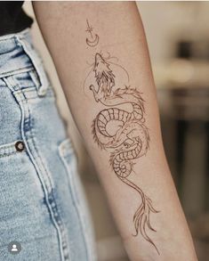 a woman's arm with a tattoo on it and a dragon in the middle