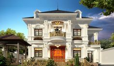 a large white house with a red door and balcony on the second floor is surrounded by greenery