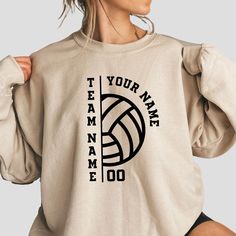 a woman wearing a sweatshirt with the words team name on it and a volleyball ball