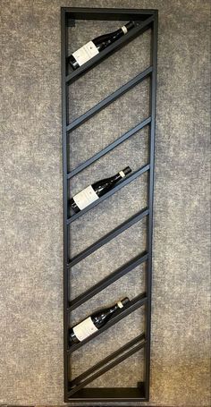 a wine rack with three bottles in it on the wall next to a carpeted floor