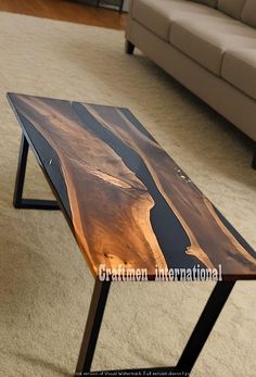 a wooden table sitting on top of a white carpeted floor next to a couch