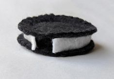 a small black and white object sitting on top of a white tablecloth covered surface