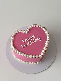 a heart shaped birthday cake with the words happy birthday written in white letters on it