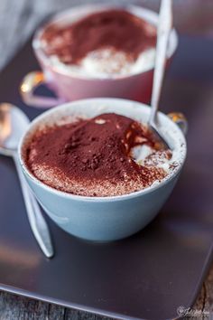 two bowls filled with chocolate pudding and spoons