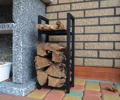 a stack of firewood sitting next to a brick wall on top of a patio