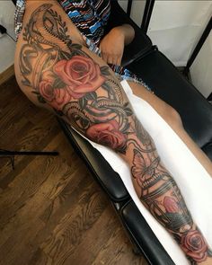 a person sitting in a chair with a tattoo on their leg