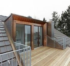 a wooden deck with stairs leading up to the roof