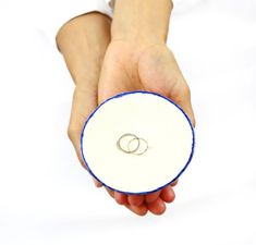 a person holding a white and blue object with two rings on it's side