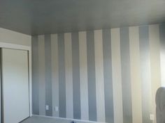 an empty room with striped walls and carpet