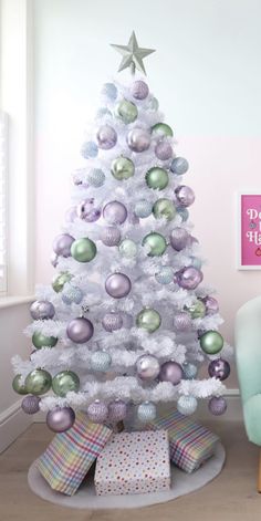 a white christmas tree with silver and green ornaments