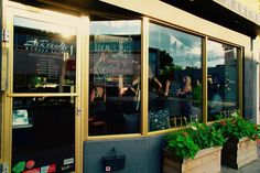 the front window of a restaurant with people sitting in it and writing on the windows