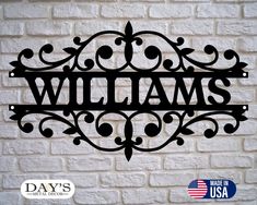 a metal sign that says, williams on it's side against a brick wall