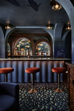 a bar with three stools in front of it