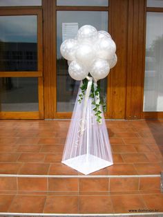 a bunch of balloons that are sitting on the ground in front of a door way