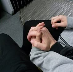 someone is holding their hands together while sitting down