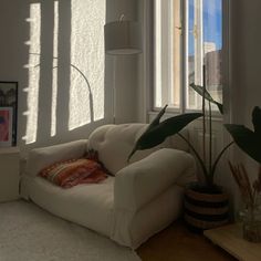 a living room filled with furniture and a large window covered in sun shining through the blinds