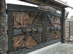 an old wooden gate with carved animals on it