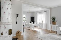 a living room filled with furniture and a fire place next to a white table covered in flowers