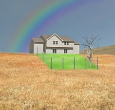 a house in the middle of a field with a rainbow above it and a tree