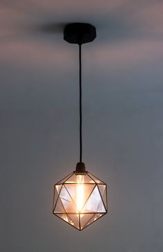 a light fixture hanging from the ceiling with a small diamond shaped light bulb attached to it