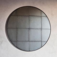 a round mirror hanging on the side of a wall