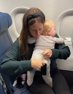 a woman holding a baby on an airplane