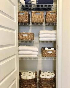 an organized closet with baskets and towels