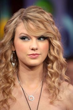 the beautiful taylor swift is smiling and wearing her hair in curly, blonde curls with bangs